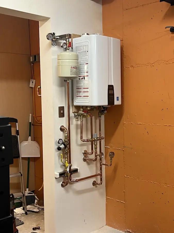 Plumbing technician inspecting water heater connections in Granbury
